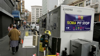 A woman walks past a 'Pit Stop' public toilet on Sixth Street, Thursday, Aug. 1, 2019, in San Francisco.