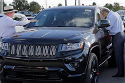 In this Thursday, Nov. 5, 2015, file photo, salesperson Andrew Montalvo, left, talks to a customer checking out the interior of a 2015 Grand Cherokee Limited in Doral, Fla. Fiat Chrysler is betting the SUV craze is here to stay and drivers around the world will want even more Jeeps. The company said Wednesday, Jan. 27, 2016, it predicts Jeep brand sales will nearly double to 2 million worldwide by 2018. (AP Photo/Alan Diaz, File)