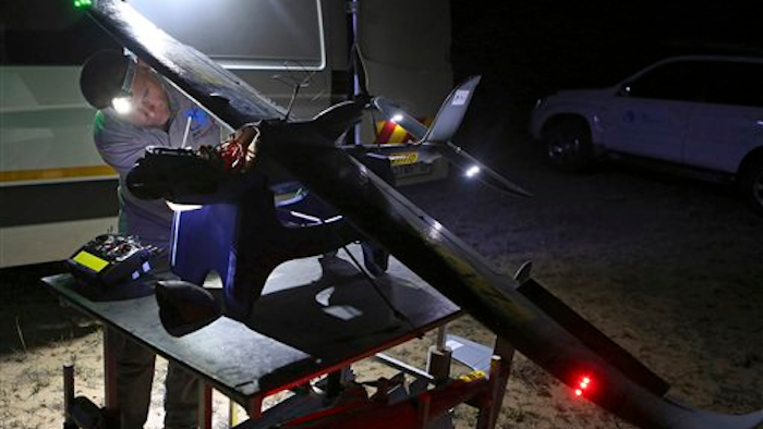 In this photo taken Monday, Feb. 15, 2016 a drone is prepared for flight in the Hluhluwe-iMfolozi Game Reserve in the KwaZulu Natal province. Once in flight conservationists can scan live video from a camera attached to the drone looking for poachers in the bush or next to the reserve to help curb the the slaughter of rhinos.