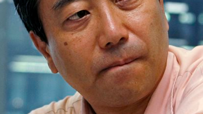 In this July 29, 2013 file photo, Masaharu Hamada, an employee of Japanese medical- device maker Olympus Corp., listens to his lawyer during an interview in Tokyo. The corporate whistleblower's eight-year courtroom battle against Olympus has ended with a financial settlement and a promise from the company to end its harassment of the man. Hamada and the company reached the settlement Thursday, Feb. 18, 2016, which awarded Hamada 11 million yen ($110,000). Legal settlements for individuals in Japan are typically small.
