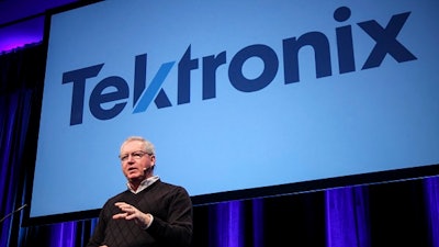 Tektronix President Pat Byrne unveils the new company logo at a recent employee meeting.