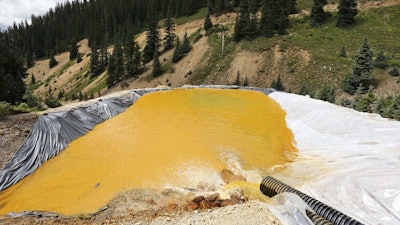 In this August 12, 2015, file photograph, water flows through a series of retention ponds after a spill at the Gold King mine near Silverton, Colorado.