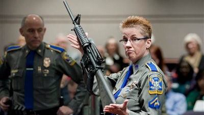 In this Jan. 28, 2013, file photo, firearms training unit Detective Barbara J. Mattson, of the Connecticut State Police, holds up a Bushmaster AR-15 rifle, the same make and model of gun used by Adam Lanza in the Sandy Hook School shooting, during a hearing of a legislative subcommittee, at the Legislative Office Building in Hartford, Conn. Lawyers for the company that made the rifle Lanza used at Sandy Hook Elementary School in 2012 are expected to ask a Connecticut judge Monday, Feb. 22, 2016, to dismiss a wrongful death lawsuit filed by families of some of the massacre victims. Freedom Group, the Madison, North Carolina parent company of AR-15 maker Bushmaster Firearms, says it’s protected by a 2005 federal law that shields gun manufacturers from most lawsuits over criminal use of their products.