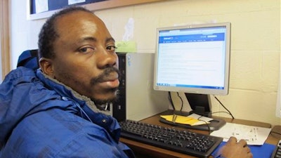 In this Jan. 29, 2016 photo, Kennedy Mugemuzi poses for a photo at the Job Service office in Williston, N.D. Mugemuzi, a native of the Congo, moved to the oil patch city a year ago and works two full-time jobs to support his wife and three children. He is among the optimistic in the city where the oil boom gravy days are waning due to depressed oil prices.