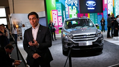 Ford CEO Mark Fields talks during an interview next to the new Kuga SUV car, which features its latest connectivity and driver-assisted technology, during the Mobile World Congress Wireless show.