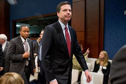 FBI Director James Comey, center, departs following a House Intelligence Committee hearing on world wide threats on Capitol Hill in Washington, Thursday, Feb. 25, 2016. Comey says Apple had been 'very cooperative' in the dispute and that there have been 'plenty' of negotiations between the two sides.