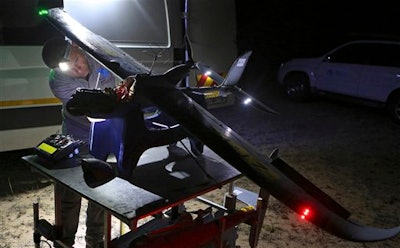 In this photo taken Monday, Feb. 15, 2016 a drone is prepared for flight in the Hluhluwe-iMfolozi Game Reserve in the KwaZulu Natal province. Once in flight conservationists can scan live video from a camera attached to the drone looking for poachers in the bush or next to the reserve to help curb the the slaughter of rhinos.