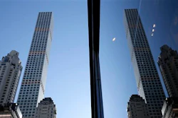 A building at 432 Park Avenue is reflected in another skyscraper in Manhattan, New York, Thursday, Feb. 18, 2016. The last few years have seen the rise of the supertall, a building standing more than 300 meters high. New technologies have allowed the buildings to have footprints no more than the width of a brownstone or two, a far cry from the massive city block an older building like the Empire State Building requires.