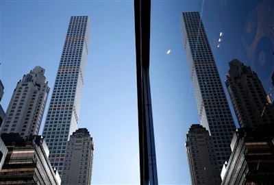 A building at 432 Park Avenue is reflected in another skyscraper in Manhattan, New York, Thursday, Feb. 18, 2016. The last few years have seen the rise of the supertall, a building standing more than 300 meters high. New technologies have allowed the buildings to have footprints no more than the width of a brownstone or two, a far cry from the massive city block an older building like the Empire State Building requires.