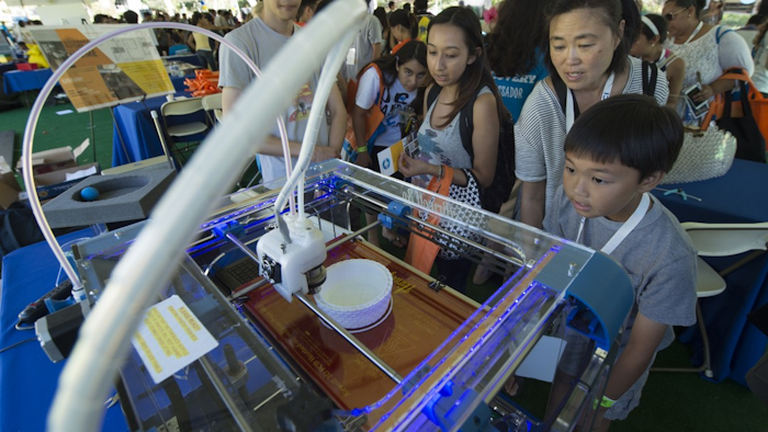 A 3D printer enthralls visitors at UCI's Festival of Discovery last fall. A new UCI study has found that the machines emit sounds, vibrations and other signals that present opportunities for industrial espionage.