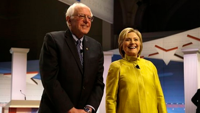 In this Feb. 11, 2016 file photo, Democratic presidential candidates Sen. Bernie Sanders, I-Vt, left, and Hillary Clinton smile as they take the stage before a Democratic presidential primary debate at the University of Wisconsin-Milwaukee, in Milwaukee. Clinton and Sanders are putting the global economy at the center of their pitch to Democrats, trading charges about who would best represent American workers as their presidential campaign shifts to a series of Rust Belt primaries.