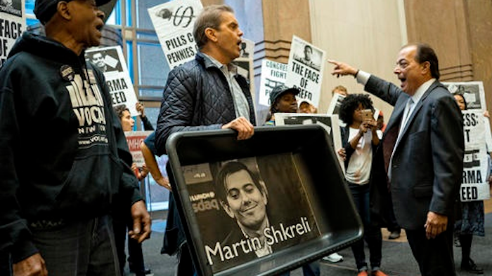 In this Thursday, Oct. 1, 2015, file photo, carrying an image of Turing Pharmaceuticals CEO Martin Shkreli in a makeshift cat litter pan, AIDS activists and others are asked to leave the lobby during a protest highlighting pharmaceutical drug pricing. The same strategy that Shkreli used to get away with a 5,000-percent price increase on an old drug is used by many other drugmakers to maintain sky-high prices on billions of dollars’ worth of medications. Shkreli, who resigned from Turing Pharmaceuticals in December 2015, was arrested and has pleaded not guilty to securities fraud and conspiracy charges.