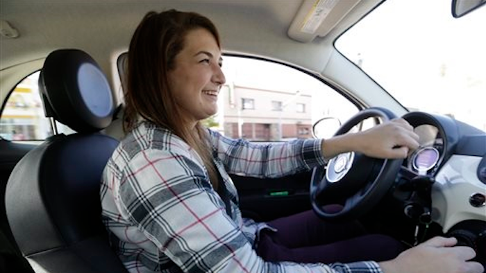 In this Monday, Dec. 21, 2015, photo, Lucy Mueller drives her 2015 Fiat 500 in Los Angeles. Mueller lived in Los Angeles for eight years without a car before she finally bought one in July. Mueller took buses and trains, hitched rides with friends and used ride-sharing services like Lyft. Her commutes lasted more than an hour each way.