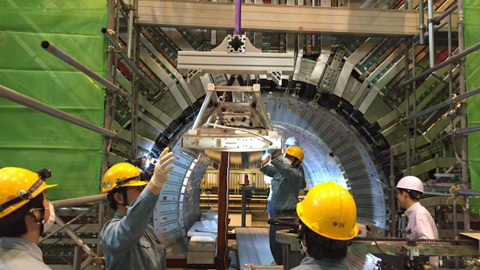 Scientists and technicians insert one of the optical components of the iTOP detector into the Belle II detector. The Belle II detector weighs about 1,400 tons and is approximately 26 feet high, wide and deep. The detector will catch the action when positrons and electrons collide in the SuperKEKB accelerator.
