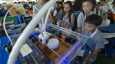 A 3D printer enthralls visitors at UCI's Festival of Discovery last fall. A new UCI study has found that the machines emit sounds, vibrations and other signals that present opportunities for industrial espionage.