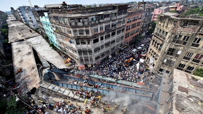Locals and rescue workers clear the rubbles of a partially collapsed overpass in Kolkata, Thursday, March 31, 2016. Rescuers dug through large chunks of debris from the overpass that collapsed while under construction Thursday, killing many people and injuring scores of others, officials said.