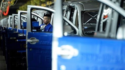 A worker labors on the assembly line of minivans at a SAIC-GM joint venture in Qingdao in eastern China's Shandong province Tuesday March 1, 2016. China's manufacturing lost momentum again last month, according to two surveys of factory activity released Tuesday, that highlighted sluggish conditions in the world's second biggest economy.