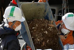 In this Feb. 24, 2016 photo, workers collect radioactive soils at a private house's garden in Minamisoma, Fukushima Prefecture, northeastern Japan. Some 7,000 day laborers are cleaning up this irradiated town just north of the Fukushima nuclear plant, wiping roof tiles and removing soil and plants in a seemingly never-ending battle against winds that bring fresh contamination.