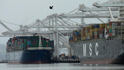 In this Thursday, March 3, 2016 photo, container ships are moored to docks at the Port of Oakland in Oakland, Calif. On Thursday, March 17, 2016, the Commerce Department reports on the U.S. current account trade deficit for the 2015 October-December quarter.