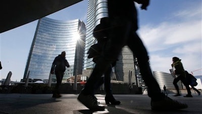 People walk in the Porta Nuova business center in Milan, Italy, Friday, March 11, 2016. European Central Bank launched an unexpectedly broad array of stimulus measures Thursday aimed at boosting a modest economic recovery in the 19 countries that use the euro and nudging up dangerously low inflation.