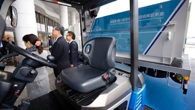 A Toyota fuel cell forklift, front, and a hydrogen fueling station and carrying hydrogen, background, are displayed in Yokohama, near Tokyo, after a press event for Hydrogen Supply Chain Demonstration Project Monday, March 14, 2016.
