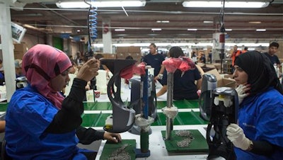 In this Wednesday, Sept. 2, 2015 file photo, employees work at the new SodaStream factory built deep in Israel's Negev Desert next to the city of Rahat, Israel. The layoffs of hundreds of workers following the closure of Israeli drinks maker SodaStream’s West Bank factory has even some Palestinians questioning the wisdom of the anti-Israel boycott movement. The fundamental contradiction: While Palestinians support the international outcry against the occupation of the West Bank, businesses attached to Israel’s far richer economy nonetheless offer much-needed jobs.