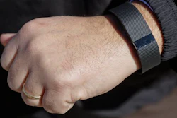 In this Monday, Feb. 29, 2016, photo, Brett Broviak, a manager of respiratory and sleep services at IU Health North Hospital, shows off his Fitbit fitness tracker for the camera on the hospital's campus in Carmel, Ind. Companies and insurers looking to reduce health-care costs are turning to incentives and may soon start rewarding you for wearing a fitness device that tracks your steps, heart rate and more.
