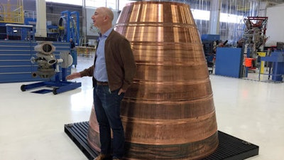 Amazon.com founder Jeff Bezos stands next to a copper exhaust nozzle to be used on a space ship engine during a media tour of Blue Origin, the space venture he founded, Tuesday, March 8, 2016, in Kent, Wash. The private space company opened its doors to the media for the first time on Tuesday to give a glimpse of how organizations like Blue Origin are creating the next generation of rockets for private and public use.