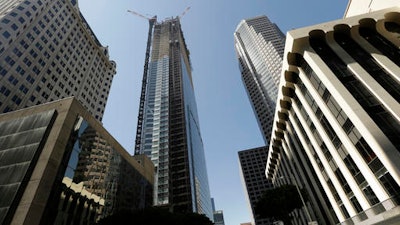 Passerby's look up at the Wilshire Grand Tower on South Figueroa Street where a worker fell to his death on Thursday, March 17, 2016. A fire department spokesperson said the the construction worker plunged 50 stories to his death from the building under construction and hit the back of a passing car in downtown Los Angeles.