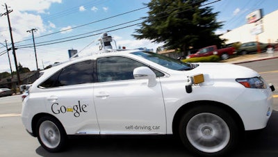 In this May 13, 2015, file photo, Google's self-driving Lexus car drives along street during a demonstration at Google campus in Mountain View, Calif. A self-driving car being tested by Google struck a public bus on a city street, a fender-bender that appears to be the first time one of the tech company's vehicles caused an accident. The collision occurred on Valentine's Day and Google reported it to California's Department of Motor Vehicles in an accident report that the agency posted Monday, Feb. 29.