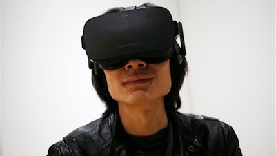 In this Jan. 6, 2016 file photo, Peijun Guo wears the Oculus Rift VR headset at the Oculus booth at CES International in Las Vegas. The consumer version of the Oculus Rift will arrive for early adopters on Monday, March 28, 2016, kicking off a new wave of high fidelity virtual reality available for people’s homes.