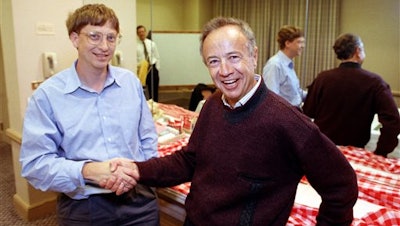 In this Nov. 9, 1992, file photo, Intel Corp. President Andy Grove, right, shakes hands with Microsoft Chairman Bill Gates at a meeting in Burlingame, Calif.