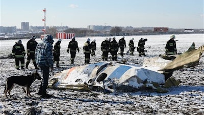 Russian Emergency Ministry employees investigate the wreckage of a crashed plane at the Rostov-on-Don airport, south of Moscow, Russia, Sunday, March 20, 2016.