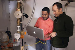 Utah State University Assistant Professor of Civil and Environmental Engineering Jeff Horsburgh, right, and student Miguel Leonardo Feliz work to configure a new 'smart' water meter at a campus dormitory building.