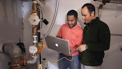 Utah State University Assistant Professor of Civil and Environmental Engineering Jeff Horsburgh, right, and student Miguel Leonardo Feliz work to configure a new 'smart' water meter at a campus dormitory building.