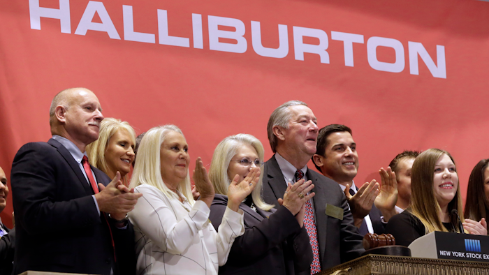 In this file photo, Halliburton Chairman, President and CEO David Lesar, third from right, rings the New York Stock Exchange opening bell. Halliburton and Baker Hughes announced their plan to combine in November 2014. The U.S. Justice Department is expected to sue to stop the acquisition, but the lawsuit had not yet been announced.