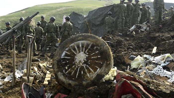Members of the Japan Self-Defense Forces work to retrieve the body of a missing person found at the site of a landslide in Minamiaso, Kumamoto prefecture, Japan Tuesday, April 19, 2016. Minamiaso, a town of 12,000 on the southern island of Kyushu, was partly cut off by landslides and road and bridge damage after earthquakes.