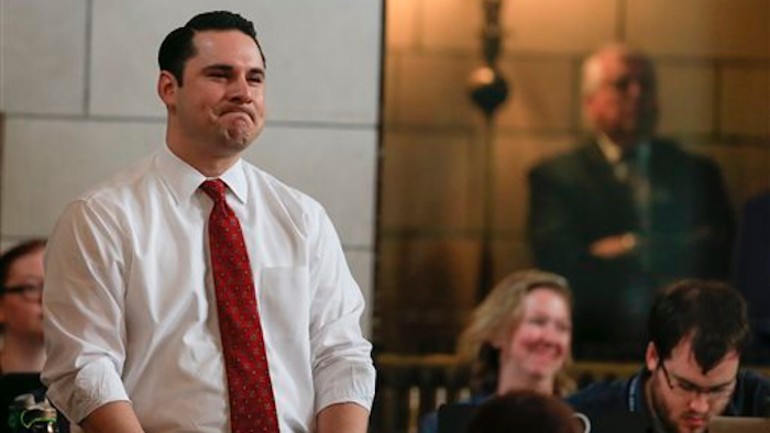 Nebraska state Sens. Heath Mello of Omaha, left, and Tanya Cook of Omaha, bottom right, react in Lincoln, Neb., Wednesday, April 20, 2016, after lawmakers overrode their Republican governor’s veto to approve a law allowing certain immigrants brought to the U.S. illegally as children to work in health care, education and dozens of other professions that require state licenses.