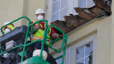 In this June 18, 2015 file photo, a crew works on the remaining wood of an apartment building balcony that collapsed in Berkeley, CA.