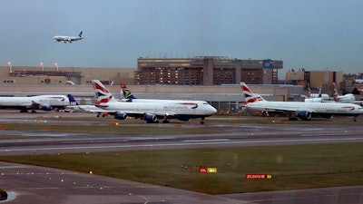 In this 2014 file photo, aircraft wait on the tarmac at Heathrow Airport in London. A collision between a British Airways passenger jet and a drone left the plane undamaged, but the aviation industry shaken. British police and air-accident authorities are investigating the incident.