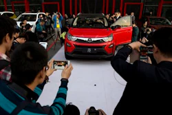 In this photo taken Monday, April 11, 2016, visitors examine the Yuan, BYD's latest Plug-in Hybrid mini SUV introduced at the BYD Dreams Conference in Beijing, China. Industry data released Tuesday, April 12, 2016 show that Chinese auto sales rose by nearly 10 percent last month, led by strong demand for SUVs that more than offset slipping passenger car sales.