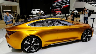 Journalists take pictures of the Roewe Vision R Concept on display at the Beijing International Automotive Exhibition. Automakers showcased a new generation of luxurious SUVs at China's biggest auto show of the year to lure buyers in its cooling, crowded market. (AP Photo/Andy Wong)