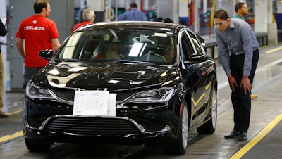 In this March 14, 2014 file photo, a 2015 Chrysler 200 automobile rolls down the assembly line. Fiat Chrysler will lay off about 1,300 workers at an assembly plant north of Detroit this summer for an indefinite time due to slow sales of midsize cars made at the factory.
