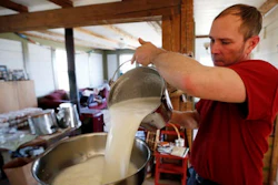 Phil Retberg pours a pail of milk that will be made into cheese in the family kitchen at the Quill's End Farm in Penobscot, Maine. Retberg said the food sovereignty movement is about protecting community as much as it's about protecting farms.