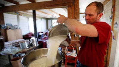 Phil Retberg pours a pail of milk that will be made into cheese in the family kitchen at the Quill's End Farm in Penobscot, Maine. Retberg said the food sovereignty movement is about protecting community as much as it's about protecting farms.