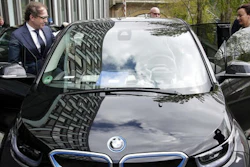 German Transportation Minister Alexander Dobrindt, left, and his staff members get in the minister's e-car after a press conference in Berlin, Germany, Wednesday, April 27, 2016. Germany plans to subsidize electric cars in a bid to help the country's auto industry compete in the global market for the growingly-popular and environmentally friendly vehicles.