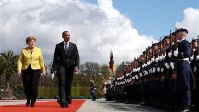 German Chancellor Angela Merkel, left, and U.S. President Barack Obama review the guard of honour at Herrenhausen Palace in Hannover, northern Germany, Sunday, April 24, 2016. Obama is on a two-day official visit to Germany.