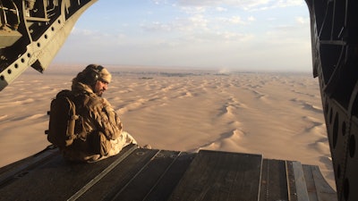 In this file photo, an Emirati gunner watches for enemy fire from the rear gate of a United Arab Emirates Chinook military helicopter flying over Yemen. The United Arab Emirates is taking part in regional conflicts and likely has spent into the billions of dollars to support its military in 2015 as well, a new report revealed. Both the UAE and Saudi Arabia also sent troops into Bahrain to put down its 2011 Arab Spring-inspired protests.