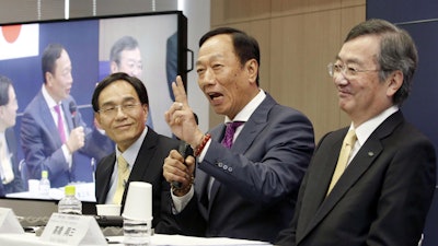 Hon Hai Precision Industry Co. Ltd., also known as Foxconn, Chairman Terry Gou, center, answers a reporter's question next to Sharp President Kozo Takahashi, right, during a press conference.