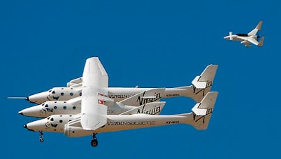 A chase plane flies on the tail of the WhiteKnightTwo and SpaceshipTwo as it soars above the runway of Spaceport America in Upham, NM, during the 2010 runway dedication ceremony. A team of pilots, ground crew and mission control specialists are at the spaceport for a week of air and ground testing in preparation for future commercial space flights at the remote patch of desert in Sierra County.